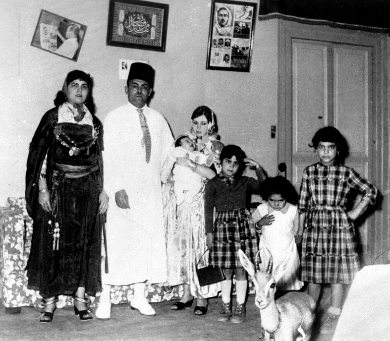 Portrait de famille de Lazhar Chraïti, en habit blanc, entouré de sa famille à la maison.
